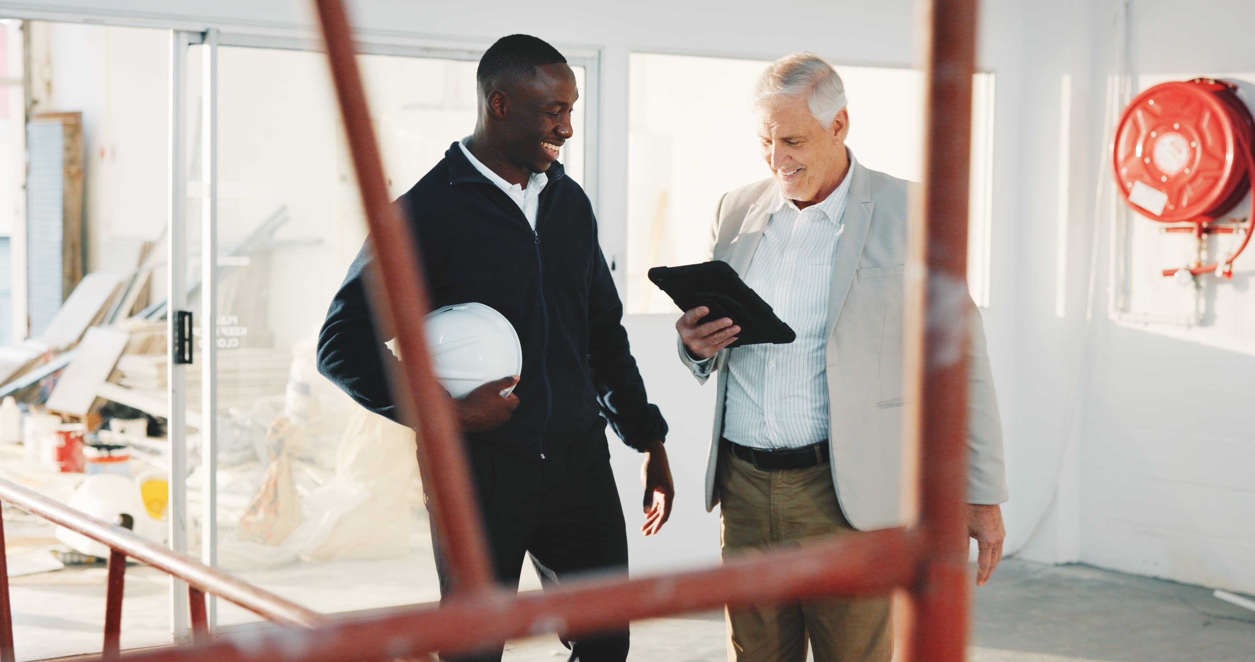 Happy, architect and team on construction site with tablet, partnership and satisfaction for project. Manager, people and smile in building with tech, online checklist and good news for renovation.