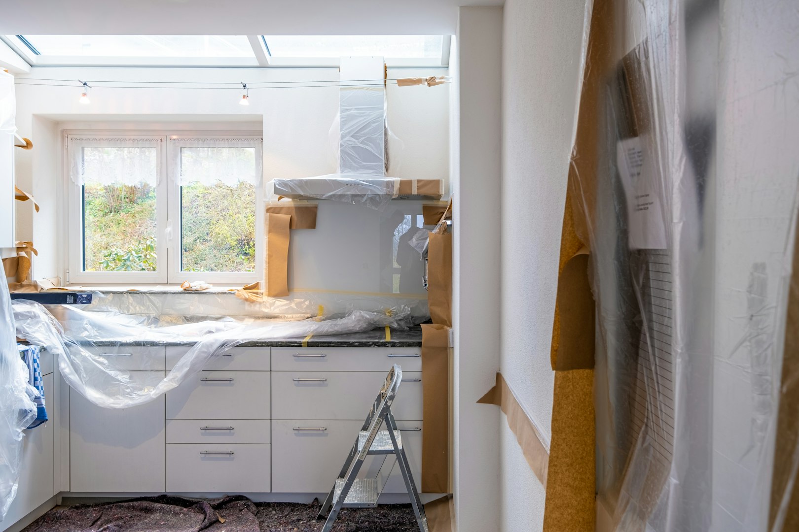 Construction worker installing luxury vinyl plank flooring using glue down method