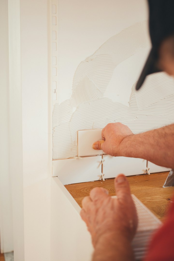 Construction worker installing luxury vinyl plank flooring using glue down method